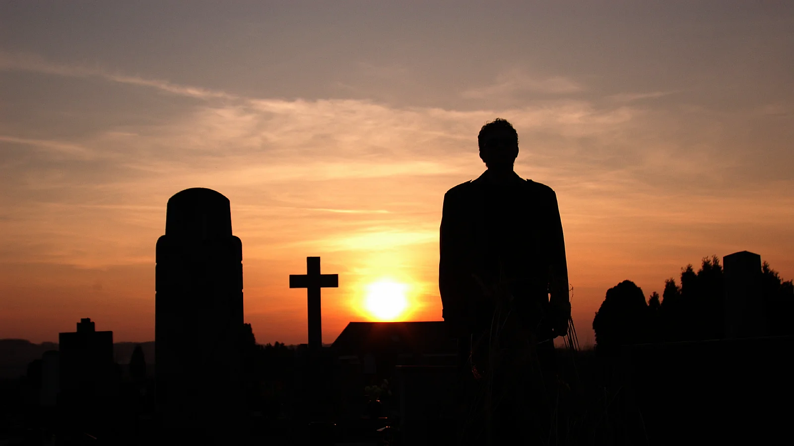 Silhouette of the creator of Zlurad in a cemetery at sunset
